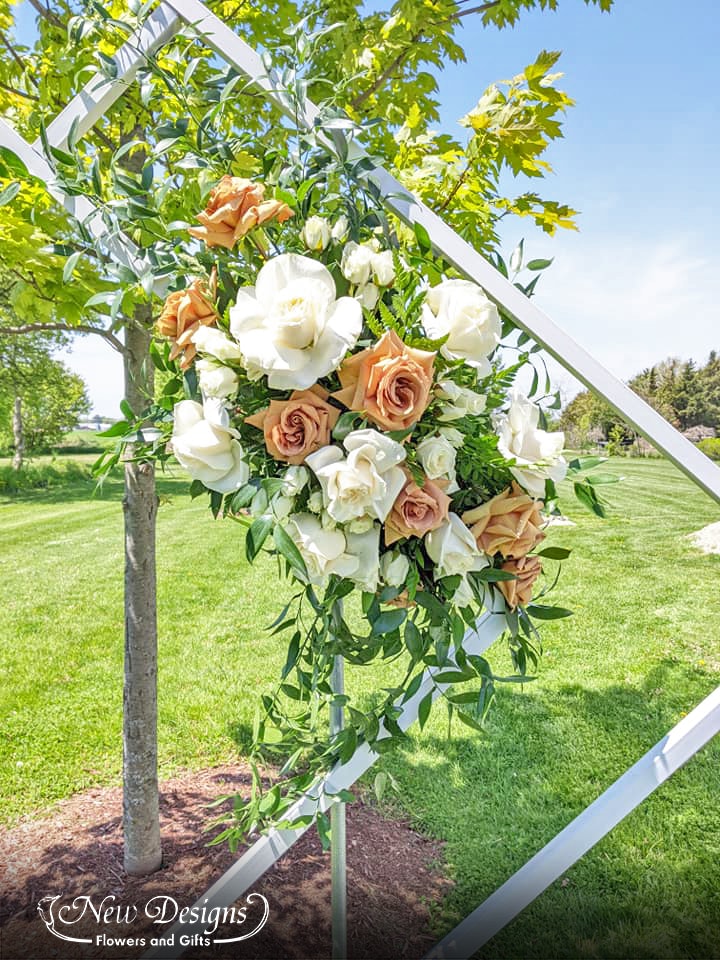 A Double Diamond Arch closeup of 1 installment of florals, with large white roses and Large Toffee Roses,